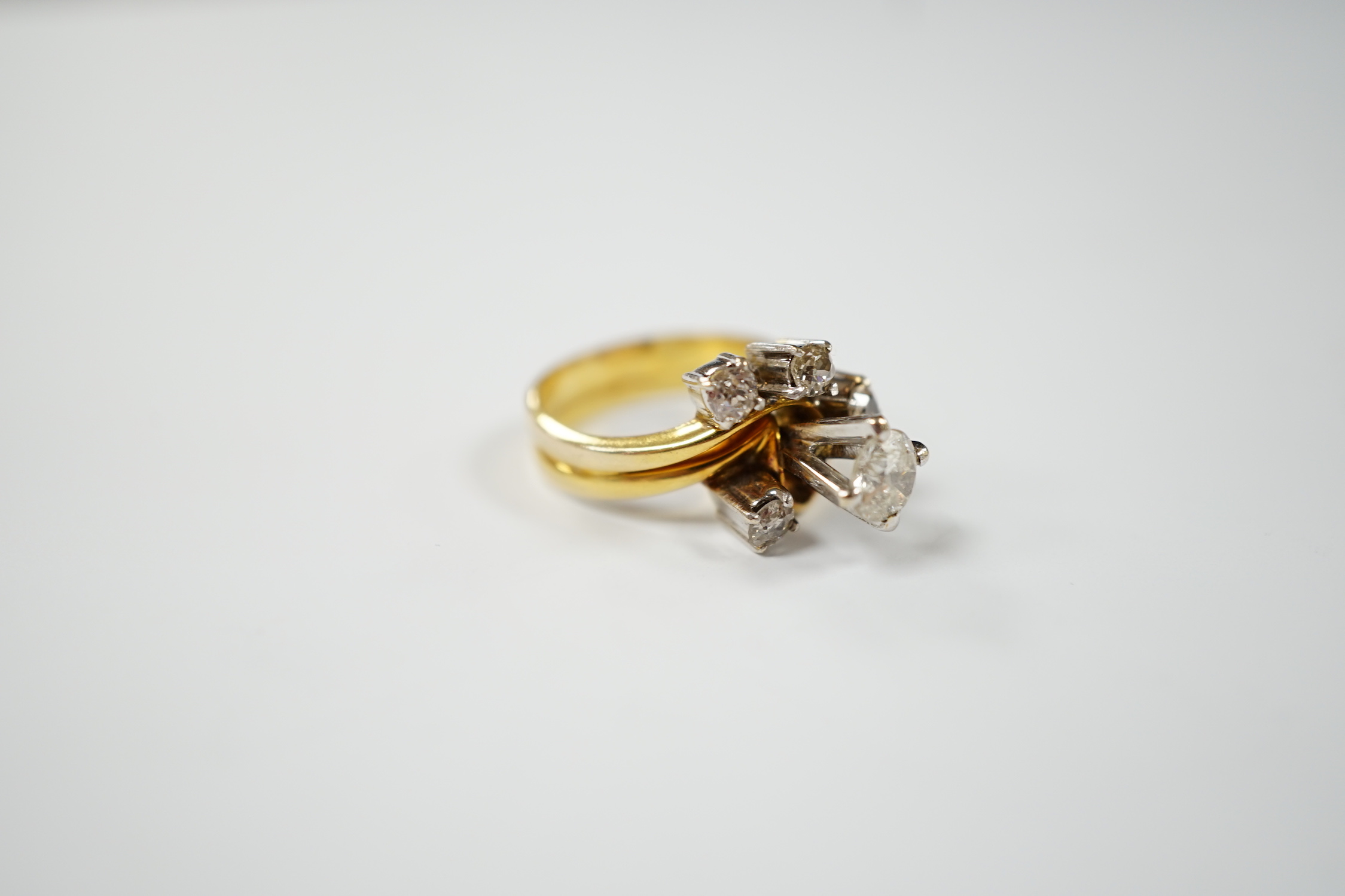 A yellow metal and graduated five stone diamond cluster set dress ring, in a raised setting, size J/K, gross weight 5.5 grams.